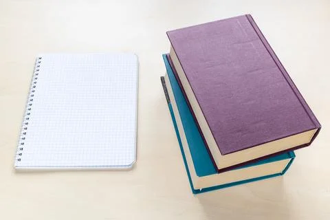 Two thick books and blank spiral notebook Stock Photos
