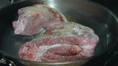 Two thick cuts of seasoned pork searing in a skillet Vídeo Stock 339036647