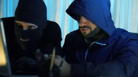 Two thief hacker working on laptop in the night stealing data Stockbeeldmateriaal 70565500