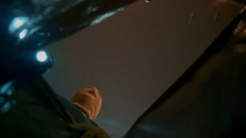 Two thieves with their faces covered look into a large black bag Stock Footage 312985671