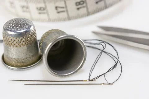 Two thimbles and two sewing needles Stock Photos