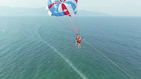 Two thrill seeking people parasailing high above the vast ocean, enjoying an 스톡 동영상 333374624
