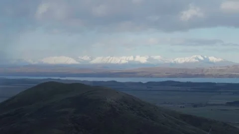 Two thumb range on horizon behind lake Pukaki, storm clouds pulling in Stock Footage 246367670