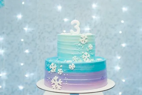 Two tier cake on blue background with unfocused lights Stock Photos