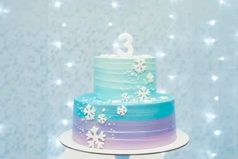 Two tier cake on blue background with unfocused lights Stock Photos