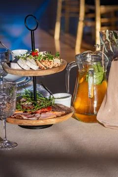 A Two-Tiered Platter of Appetizers Set on a Beige Tablecloth in an Empty Wedding Stock Photos