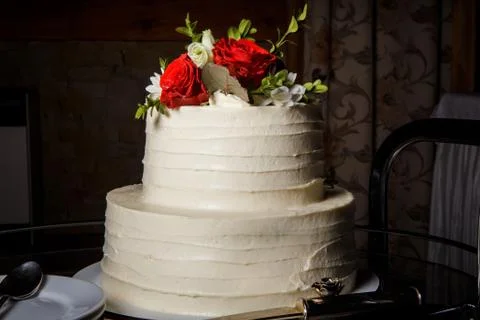 Two-tiered wedding cake decorated with red roses 写真素材
