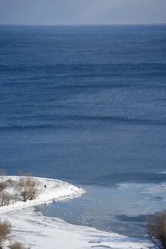 Two Tiny Figures Walking Along Frozen Lake Ontario Shoreline Stock Photos