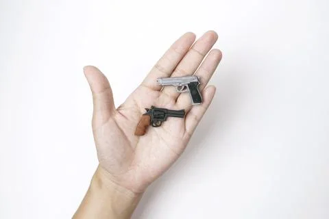 Two Tiny Model Pistol and Automatic Gun on Hand in White Background Stock Photos