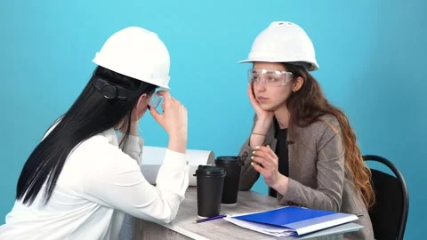 Two Tired Female Engineers Taking Off Hard Hats and Safety Glasses After Work Stock Footage 346110619