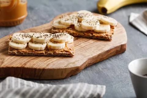 Two toasts from multi grain breads with peanut paste, banana slices and chia Foto stock