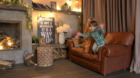 Two toddlers jumping from sofa Stock Footage 121152703