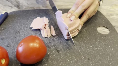 Two tomatoes are on a cutting board with a knife next to them Vídeo Stock 279052966