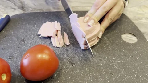 Two tomatoes are on a cutting board with a knife next to them Stock Footage 279299339