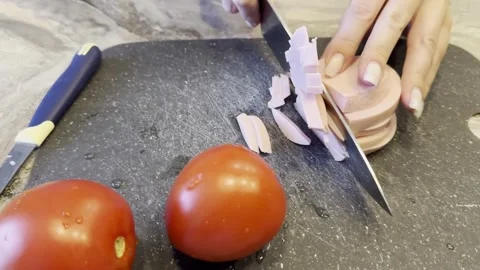 Two tomatoes are on a cutting board with a knife Stock-Footage 283488149