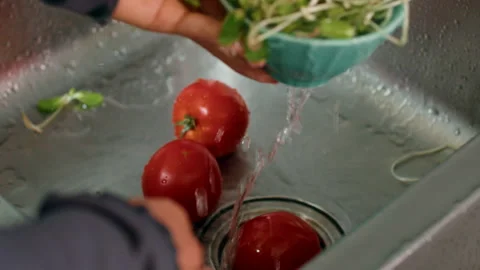 Two tomatoes being washed in sink, potential ingredient for a delicious recipe 動画素材 271224066