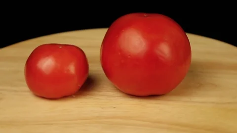 Two tomatoes of different sizes rotate 360 degrees Stock Footage 120026615