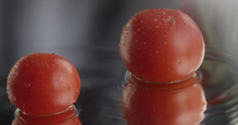 Two tomatoes slide and stop in the center of the frame Stock Footage 200256643