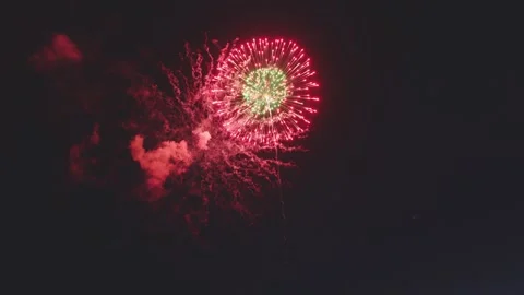 Two tone firework bursting with red outer ring and green center core Video stock 340632736