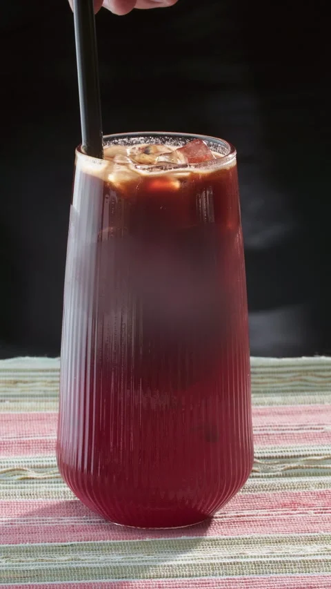 Two-tone layered drink. Dark espresso and red berry drink in a glass with ice on Stock-Footage 316167968