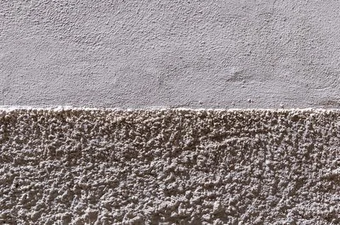 Two tone plaster wall with rough lower band and smooth upper section Foto stock