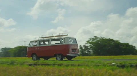 A two-tone red and white retro van (bus) driving through rice fields. Vidéo 49678975