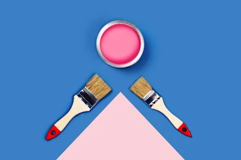 Two-toned background with pink paint jar and brushes. Stock Photos