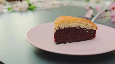 Two-Toned Cake Sitting on Pink Plate with Floral Decor on Table Stock Footage 342874969