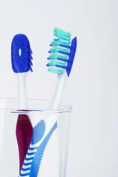 Two tooth brush in a transparent container Stock Photos