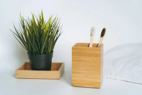 Two toothbrushes in bamboo folder. white towel and artificial flower on whi.. Stock Photos