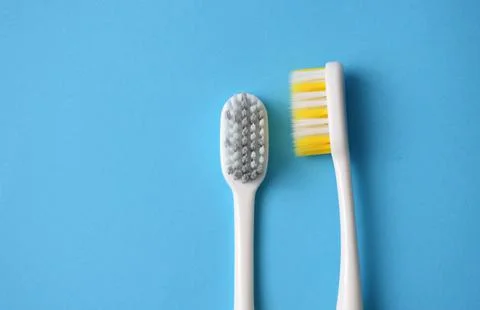 Two toothbrushes on a blue background close-up. Stock Photos