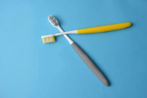 Two toothbrushes on a blue background. Stock Photos