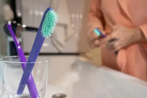 Two toothbrushes, old and new, held on a bathroom counter to highlight time.. Stock Photos
