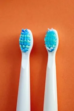 Two toothbrushes on an orange background Stock Photos