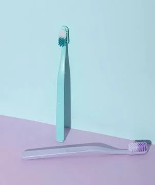 Two toothbrushes on pastel background, clean and simple scene Stock Photos