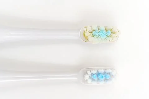 Two toothbrushes show different colors of toothpaste and bristles Stock Photos