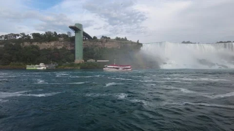 Two tour boats passing below American Falls and the Observation Tower Stock Footage 345996057