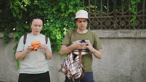 Two tourists capturing memories with cameras while exploring a scenic location Stock Footage 301105936