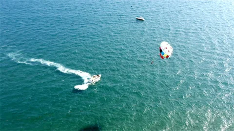 Two tourists get tons of thrills from parasailing Stock Footage 118635081