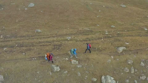 Two tourists with large backpacks and trekking poles meet two people 스톡 동영상 259793213