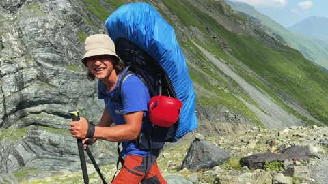 Two tourists with large backpacks are walking along a mountain trail Video stock 158667019