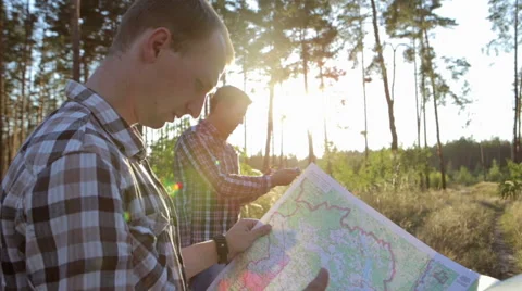 Two Tourists on a Trip, Use Map and Compass Stock Footage 67378614