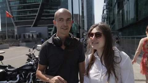 Two tourists walk through the big city on the street with skyscrapers and with Stock Footage 110893681