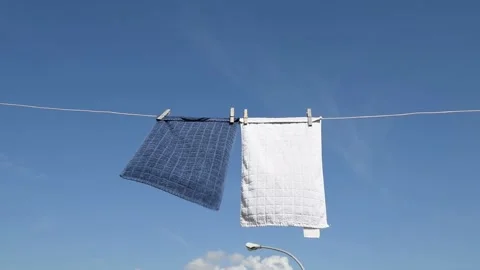 Two towels are drying on a rope on the roof of the house Stock Footage 130182769