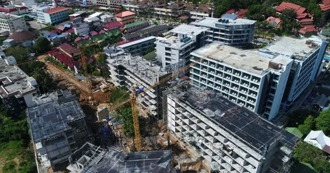 Two tower cranes over a rising hotel shell in a resort town Vídeos de archivo 71296714