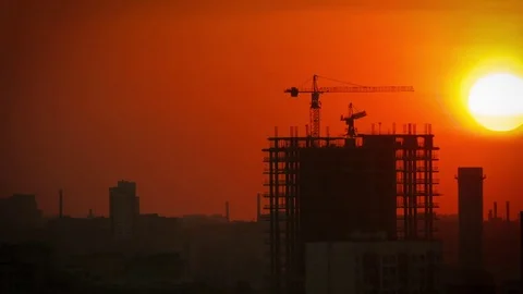 Two tower cranes at sunset are building a house. Stock Footage