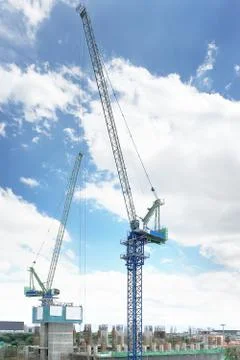 Two tower cranes working on construction site to build high-rise building. 写真素材