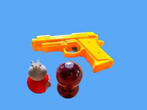 Two toy figures are looking at a toy gun Stock Photos
