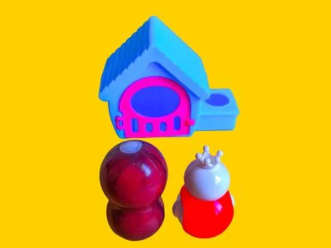 Two toy figures are looking at a toy house Stock Photos