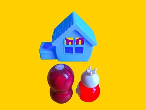 Two toy figures are looking at a toy house Stock Photos